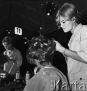 Listopad 1968, Warszawa, Polska.
Stołeczny konkurs fryzjerski spółdzielczości pracy, fryzjerka układająca włosy modelce.
Fot. Jarosław Tarań, zbiory Ośrodka KARTA
