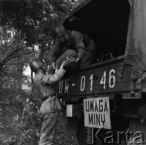 Wrzesień 1968, Warszawa, Polska.
Forty Twierdzy Warszawa na Mokotowie. Rozminowywanie. Żołnierze ładujący na ciężarówkę pocisk-niewypał. 
Fot. Jarosław Tarań, zbiory Ośrodka KARTA