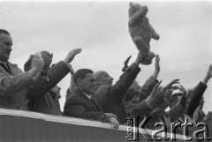 01.05.1963, Warszawa, Polska.
Święto 1 Maja. Dostojnicy państwowi na trybunie honorowej. Wśród nich I sekretarz KC PZPR Władysław Gomułka macha pluszowym misiem, obok niego stoi Aleksander Zawadzki.
Fot. Jarosław Tarań, zbiory Ośrodka KARTA [63-46]

