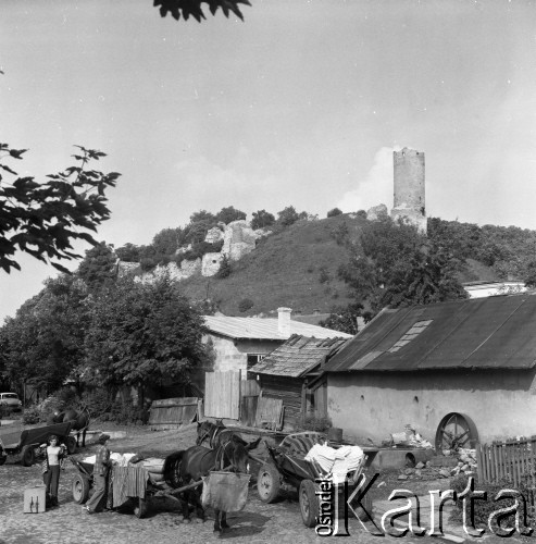 23.08.1979, Iłża, woj. kieleckie, Polska.
Widok na gospodarstwo wiejskie - kobiety stoją przy wozach, konie, zabudowa mieszkalna. W oddali widoczne są ruiny Zamku Biskupiego na Górze Zamkowej.
Fot. Jarosław Tarań, zbiory Ośrodka KARTA [79-48]