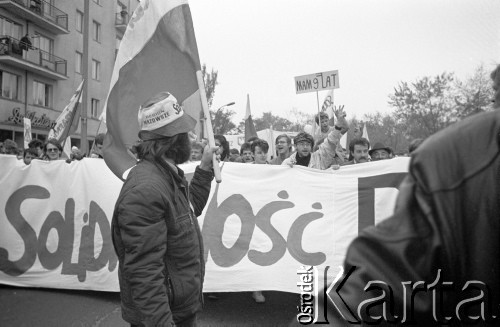 1.05.1989, Warszawa, Polska.
Niezależna manifestacja 1-majowa na placu Komuny Paryskiej (wcześniej i obecnie Plac Wilsona) na Żoliborzu, w pobliżu kościoła św.Stanisława Kostki, parafii księdza Jerzego Popiełuszki. 
W pierwszym rzędzie idą liderzy NZS-u, od prawej z wąsami - Jacek Ziemiński. Wśród manifestantów mały chłopiec z transparentem: 
