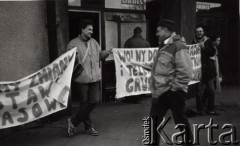 1989, Warszawa, Polska.
Plac Wilsona, akcja Ruchu Wolności Słowa. Na pierwszym planie przechodzący Jacek Kuroń. Napisy na transparentach: 