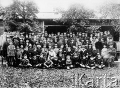 1920, Milanówek, Polska.
Ochotnicza Straż Obywatelska w czasie wojny polsko-bolszewickiej. W pierwszym i drugim rzędzie siedzą skauci: 4. z lewej Bolesław Jastrzębski, 6. z lewej Garbarek, 7. Juliusz Frasunkiewicz. W drugim rzędzie 5. z lewej Antoni Packo, 7. Mirosław Krasnodębski, 8. Janusz Gumkowski. W trzecim rzędzie 6. z lewej generał Odyniec, za nim Frasunkiewicz [ojciec], Csaky i ksiądz Trompeteler [w cylindrze]. W czwartym rzędzie 4. z lewej stoi pani Janowska, 1. z prawej Frasunkiewicz [dziadek], z lewej na krześle stoi Hagmayer. W piątym rzędzie pierwszy od lewej stoi Okołokułak [ojciec wiceprezydenta Warszawy].
Fot. NN, zbiory Ośrodka KARTA, udostępniła Zofia Światłowska