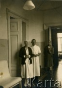 Przed wrześniem 1939, Polska.
Doktor Kazimierz Wolfram (w środku) – przed wojną wybitny chirurg warszawski, we wrześniu 1939 aresztowany, więzień obozu w Starobielsku, rozstrzelany w Charkowie. Na zdjęciu na szpitalnym korytarzu z pielęgniarką i pacjentem w czasie wykonywania obowiązków służbowych.
Fot. NN, zbiory Ośrodka KARTA, kolekcja Kazimierza Wolframa [AW III/329]