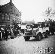 Lata 50., Pszczółki, woj. gdańskie, Polska.
Defilada pierwszomajowa. Na trybunie honorowej stoją przedstawiciele partii, z prawej wisi portret Bolesława Bieruta. Na przyczepie samochodu jedzie grupa dzieci.
Fot. Czesław Wdowczyk, zbiory Ośrodka KARTA, udostępnił Henryk Wdowczyk
 
