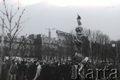 13.12.1981, Paryż, Francja.
Manifestacja pod pomnikiem Adama Mickiewicza na placu Alma zorganizowana po ogłoszeniu w Polsce stanu wojennego. Około godz. 9-10 doszło do spontanicznej manifestacji, która następnie przemaszerowała mostem Aleksandra w stronę placu Inwalidów i pod ambasadę PRL. Była to jedyna manifestacja w latach 80. w Paryżu, w trakcie której manifestanci doszli pod gmach ambasady przy rue de Talleyrand. 
Fot. Andrzej Mietkowski, zbiory Ośrodka KARTA