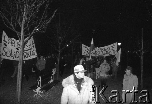 13.12.1981, Paryż, Francja.
Wieczorna manifestacja w dniu wprowadzenia w Polsce stanu wojennego. Rozpoczęła się pod pomnikiem Adam Mickiewicza, manifestanci przeszli na plac Alma i przez most Aleksandra w stronę placu Inwalidów. Dotarli pod ambasadę PRL. Na zdjęciu na transparencie napis: 