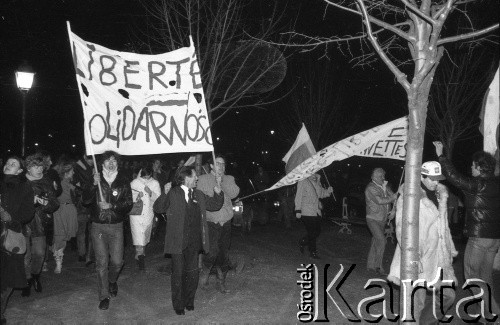 13.12.1981, Paryż, Francja.
Wieczorna manifestacja w dniu wprowadzenia w Polsce stanu wojennego. Rozpoczęła się pod pomnikiem Adam Mickiewicza, manifestanci przeszli na plac Alma i przez most Aleksandra w stronę placu Inwalidów. Dotarli pod ambasadę PRL. Na zdjęciu na transparencie napis: 