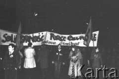 15.12.1981, Paryż, Francja
Manifestacja przeciwko wprowadzeniu w Polsce stanu wojennego zorganizowana przez związki zawodowe. Była pierwszą, w której wzięły udział największe francuskie związki zawodowe poza komunistami. Obok siebie szły: Force Ouvriere, CFDT - Confédération française démocratique du travail, CFTC - Confédération Française des Travailleurs Chrétiens, CGC- Confédération Française de l'Encadrement - Confédération Générale des Cadres. Około godziny 17-18 kilkadziesiąt tysięcy manifestantów ruszyło spod wieży Montparnasse. Na zdjęciu na transparencie napis: „Solidarność force ouvriere”.
Fot. Andrzej Mietkowski, zbiory Ośrodka KARTA