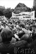 1981-1982, Paryż, Francja.
Manifestacja zorganizowana przez francuskie związki zawodowe na placu Inwalidów, obok ambasady PRL przy rue de Talleyrand. Wzięły w niej udział: Force Ouvriere, CFDT - Confédération Française Démocratique du Travail, CFTC - Confédération Française des Travailleurs Chrétiens, CGC- Confédération Erançaise de l'Encadrement oraz Union Nationale des Étudiants de France (UNEF).  Na zdjęciu przemawiają Jean Meretik (z lewej), brat Garbriela Meretika i Sławomir Czarlewski.
Fot. Andrzej Mietkowski, zbiory Ośrodka KARTA