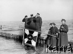 18.03.1945, Kołobrzeg, Polska.
Moment uroczystych zaślubin z morzem sztandaru 10 pp, ufundowanego przez mieszkanców warszawskiej dzielnicy Praga. Sztandar trzyma chór. Władysław Spodynek. Na drewnianym falochronie stoją: z-ca d-cy pułku kpt. Kamiński, d-ca pułku płk. Wincenty Potopowicz i szef sztabu pułku ppłk. Zduhowski (Zdubowski?).
Fot. Józef Rybicki, zbiory Fundacji Ośrodka KARTA