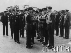 Wrzesień 1940, Londyn, Anglia, Wielka Brytania.
Baza lotnicza RAF Northolt, król Anglii Jerzy VI wizytuje polskich pilotów; na pierwszym planie z lewej G/Cpt Stanley Vincent [d-ca bazy lotniczej], w środku z lewej stoi król Jerzy VI, za nim z lewej por. Witold Urbanowicz [d-ca Dywizjonu 303], z prawej za królem angielski d-ca Dywizjonu 303 S/Idr Ronald Gustave Kellet, Jerzy VI ściska dłoń por. Mirosława Ferica, dalej w szeregu stoją: ppor. Jan Zumbach, por. Bohdan Grzeszczak, por. Wojciech Januszewicz; w drugim szeregu od prawej: kpt. Giejsztowt [oficer wywiadowczy], F/O E.H.L. Hadwin [oficer wywiadowczy, Brytyjczyk], NN.
Fot. Jan Sianos, zbiory Ośrodka KARTA, udostępnili Scholastyka i Jerzy Królowie

