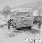 Lata 60., Nowy Sącz - Gorlice, Polska.
Pasażerowie pchają autokar na trasie Nowy Sącz - Gorlice.
Fot. Bogdan Łopieński, zbiory Ośrodka KARTA