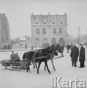 Lata 60., Kazimierz Dolny, woj. lubelskie, Polska.
Sanie zaprzężone w konie na rynku. W tle apteka przy ul. Rynek 23.
Fot. Bogdan Łopieński, zbiory Ośrodka KARTA