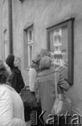 Po 16.10.1978, Wadowice, woj. krakowskie.
Mieszkańcy przed gablotą z fotografiami Jana Pawła II, wybranego na papieże 16.10.1978, na elewacji plebanii kościoła pw. Ofiarowania Najświętszej Maryi Panny, w którym Karol Wojtyła został ochrzczony.
Fot. Bogdan Łopieński, zbiory Ośrodka KARTA