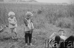 1961, Polska.
Miejscowe dzieci przyglądają się turyście leżącemu na trawie.
Fot. Bogdan Łopieński, zbiory Ośrodka KARTA