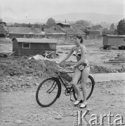 Brak daty, Polska.
Kobieta w bikini prowadzi rower.
Fot. Bogdan Łopieński, zbiory Ośrodka KARTA