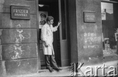 23.10.1963, Warszawa, Polska.
Wizyta radzieckich kosmonautów Walentyny Terieszkowej i Walerego Bykowskiego. Mężczyzna w wejściu do zakładu fryzjerskiego. Na drzwiach wisi portret Walerego Bykowskiego.
Fot. Bogdan Łopieński, zbiory Ośrodka KARTA