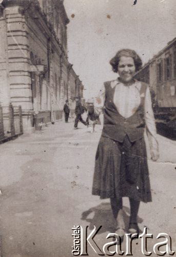 1926-1927, Ostrołęka, woj. białostockie, Polska.
Antonina Jadwiga Kołakowska (z domu Bichta) na dworcu w Ostrołęce, w tle po lewej stronie widoczny jest fragment budynku dworca, po prawej pociąg.
Fot. NN, zbiory Ośrodka KARTA, Pogotowie Archiwalne [PAF_022], udostępniła Anna Kołakowska