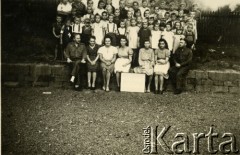 1945, Volpriehausen, III Rzesza Niemiecka.
Polski obóz przesiedleńczy. Uczniowie z przyobozowej szkoły wraz z nauczycielami na przerwie. W dolnym rzędzie pierwszy od lewej podporucznik Edmund Wojciechowski. 
Fot. zbiory Ośrodka KARTA, Pogotowie Archiwalne [PA_024], przekazali Dorota i Tomasz Wojciechowscy