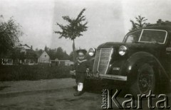 Lata 50., Śmigiel, pow. kościański, woj. poznańskie, Polska.
Marek Balcer przy taksówce Władysława Małka, marki Wanderer na Placu Wojska Polskiego. W tle zabudowania Śmigla.
Fot. NN, zbiory Ośrodka KARTA, Pogotowie Archiwalne [PA_033], przekazał Piotr Balcer