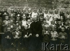 11.08.1940, Krępa, pow. Łuków, Generalne Gubernatorstwo.
Dzieci przystępujące do I Komunii Świętej z obrazkami. W górnym rzędzie, w ciemnym stroju z klapami marynarki w paski - Zygfryd Balcer, jeden z synów Walentego Balcera, weterynarza ze Śmigla zamordowanego w masowej egzekucji.
Fot. NN, zbiory Ośrodka KARTA, Pogotowie Archiwalne [PA_033], przekazał Piotr Balcer