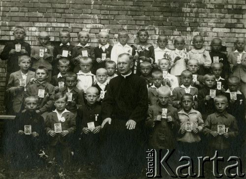 11.08.1940, Krępa, pow. Łuków, Generalne Gubernatorstwo.
Dzieci przystępujące do I Komunii Świętej z obrazkami. W górnym rzędzie, w ciemnym stroju z klapami marynarki w paski - Zygfryd Balcer, jeden z synów Walentego Balcera, weterynarza ze Śmigla zamordowanego w masowej egzekucji.
Fot. NN, zbiory Ośrodka KARTA, Pogotowie Archiwalne [PA_033], przekazał Piotr Balcer