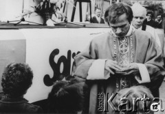 Sierpień 1981, Polska.
Ksiądz Jerzy Popiełuszko udziela Komunii podczas Mszy świętej odprawianej w rocznicę strajków w 1980 roku.  
Fot. Adam Szymański, zbiory Ośrodka KARTA.