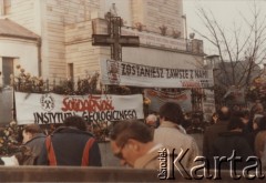 2.11.1984, Warszawa, Polska.
Przygotowania do pogrzebu księdza Jerzego Popiełuszki w Kościele św. Stanisława Kostki na warszawskim Żoliborzu - wierni przybyli na ceremonię pogrzebową. Na ogrodzeniu kościoła widoczne są transparenty: 