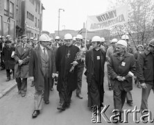 4.05.1981, Warszawa, Polska.
Wizyta biskupa Zbigniewa Kraszewskiego (z kwiatami), sufragana warszawskiego w Hucie Warszawa. Przed wydziałem W-45. Obok biskupa idzie ksiądz Jerzy Popiełuszko. Hutnicy trzymają transparent z napisem: 