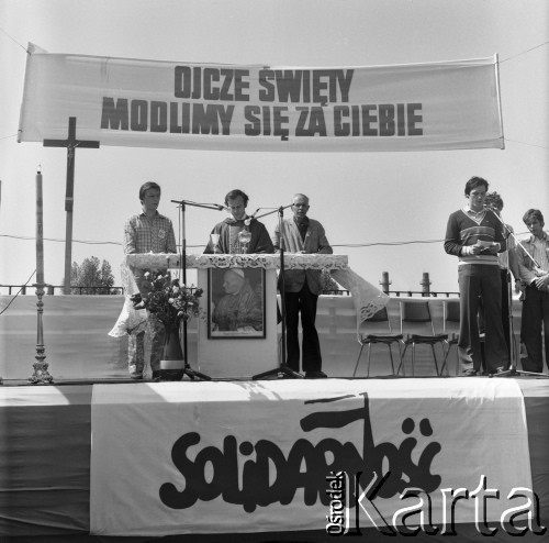14.05.1981, Warszawa, Polska.
Ksiądz Jerzy Popiełuszko odprawia Mszę świętą przed bramą Huty Warszawa. Msza sprawowana jest w intencji powrotu  do zdrowia Jana Pawła II po zamachu w Watykanie 13.05.1981. Nad ołtarzem widoczny jest transparent: 