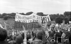 16-23.06.1983, Warszawa, Polska.
Druga pielgrzymka Jana Pawła II do Polski. Wierni - z uniesionymi do góry dłońmi złożonymi w znak zwycięstwa. Na pierwszym planie - transparent Konfederacji Polski Niepodległej.
Fot. Adam Szymański, zbiory Ośrodka KARTA, kolekcję zdjęć przekazał Adam Szymański