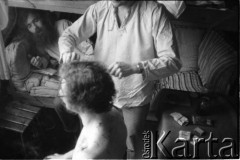 Marzec-lipiec 1982, Warszawa-Białołęka, Polska.
Ośrodek dla internowanych. Marek Chimiak obcina włosy Marka Beylina, na łóżku Andrzej Zieliński.
Fot. Maciej Kwiatkowski, zbiory Ośrodka KARTA