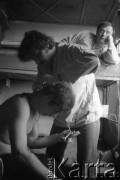Marzec-lipiec 1982, Warszawa-Białołęka, Polska.
Ośrodek dla internowanych. Marek Chimiak obcina włosy Marka Beylina. Na łóżku Marek Końka.
Fot. Andrzej Zieliński lub Maciej Kwiatkowski, zbiory Ośrodka KARTA