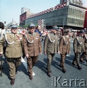 1.05.1974, Warszawa, Polska.
Obchody Święta Pracy. Żołnierze Ludowego Wojska Polskiego - przedstawiciele środowisk kombatanckich w pochodzie zmierzającym ulicą Marszłkowską. W tle dom handlowy Junior udekorowany okolicznościowym hasłem 