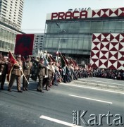 1.05.1974, Warszawa, Polska.
Obchody Święta Pracy. Przedstawiciele Ludowego Wojska Polskiego w pochodzie zmierzającym ulicą Marszłkowską. W tle dom handlowy Sawa udekorowany okolicznościowym hasłem 