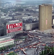 1.05.1974, Warszawa, Polska.
Obchody Święta Pracy. Rondo (obecnie rondo Dmowskiego) u zbiegu ulicy Marszałkowskiej z Alejami Jerozolimskimi - budynek Universalu udekorowany okolicznościowy propagandowym hasłem: 