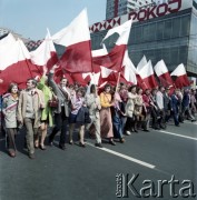 1.05.1974, Warszawa, Polska.
Obchody Święta Pracy. Uczestnicy pochodu zmierzają ulicą Marszałkowską niosąc biało-czerwone flagi. 
Fot. Edward Grochowicz, zbiory Ośrodka KARTA.