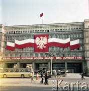 22.07.1974, Warszawa, Polska.
30. rocznica powstania Polskiej Rzeczpospolitej Ludowej. Na pierwszym planie widoczne dekoracje zawieszone na fasadzie siedziby Komitetu Centralnego Polskiej Zjednoczonej Partii Robotniczej (tzw. Dom Partii) przy Alejach Jerozolimskich.
Fot. Edward Grochowicz, zbiory Ośrodka KARTA