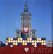 1.05.1975, Warszawa, Polska.
Obchody Święta Pracy. Pałac Kultury i Nauki udekorowany transparentem z godłem państwowym. Na pierwszym planie trybuna na  placu Defilad z okolicznościową dekoracją.
Fot. Edward Grochowicz, zbiory Ośrodka KARTA.
