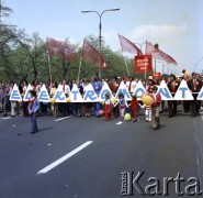 1.05.1975, Warszawa, Polska.
Obchody Święta Pracy. Uczestnicy pochodu niosą czerwone sztandary, transparenty z hasłami propagandowymi, m.in. z napisami: 