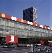 Przed 1.05.1975, Warszawa, Polska.
Przygotowania do obchodów Święta Pracy. Montowanie okolicznościowych świątecznych dekoracji przed budynkami Domów Handlowych Centrum przy ulicy Marszałkowskiej.
Fot. Edward Grochowicz, zbiory Ośrodka KARTA.
