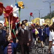 1.05.1975, Warszawa, Polska.
Obchody Święta Pracy. Uczestnicy pochodu niosą okolicznościowe dekoracje - wykonane z papieru kwiaty i transparenty.
Fot. Edward Grochowicz, zbiory Ośrodka KARTA.
