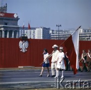 1.05.1975, Warszawa, Polska.
Obchody Święta Pracy. Uczestniczący w pochodzie pracownicy służby zdrowia oraz przedstawiciele środowisk kombatanckich zmierzają ulicą Marszałkowską. Na dalszym planie trybuna honorowa udekorowana godłem państwowym. 
Fot. Edward Grochowicz, zbiory Ośrodka KARTA.
