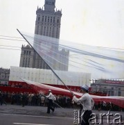 1.05.1978, Warszawa, Polska.
Obchody Święta Pracy. Przywódcy partyjni i przedstawiciele władz obserwują pochód z trybuny honorowej na placu Defilad. Mężczyźni z flagami w narodowych barwach.
Fot. Edward Grochowicz, zbiory Ośrodka KARTA