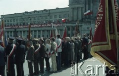 1.05.1982, Warszawa, Polska.
Uczestnicy ze sztandarami różnych organizacji biorą udział w uroczystościach pierwszomajowych na Placu Teatralnym. W głębi widoczny transparent na fasadzie Teatru Wielkiego.
Fot. Edward Grochowicz, zbiory Ośrodka KARTA
