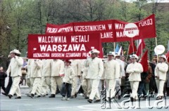 1.05.1985, Warszawa, Polska. 
Obchody Święta Pracy. Grupa mężczyzn w strojach paradnych w pochodzie zmierzającym ulicami Warszawy. Mężczyźni niosą okolicznościowe transparenty, jeden z nich głosi : 