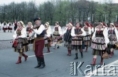 1.05.1985, Warszawa, Polska. 
Obchody Święta Pracy. Biorący udział w pochodzie ubrani w regionalne stroje łowickie członkowie grupy folklorystycznej zmierzają przez plac Teatralny. 
Fot. Edward Grochowicz, zbiory Ośrodka KARTA