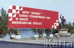 22.07.1985, Warszawa, Polska.
Dekoracja propagandowa z okazji oddania do użytku Mostu Syreny, zbudowanego w trzy miesiące przez wojsko jako przeprawa zastępcza na czas remontu mostu Poniatowskiego. Z prawej pomnik warszawskiej Syrenki.
Fot. Edward Grochowicz, zbiory Ośrodka KARTA