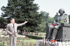 1985, Warszawa, Polska.
Uroczystości związane z odsłonięciem pomnika Ignacego Jana Paderewskiego w nowym miejscu - w Parku Ujazdowskim. Odlana z brązu rzeźba projektu Michała Kamieńskiego od 1978 ustawiona była przy ul. Okólnik, w sąsiedztwie Pałacu Ostrogskich i Państwowej Wyższej Szkoły Muzycznej. W 1985 roku pomnik przeniesiono i ustawiono w nowej lokalizacji, naprzeciwko wejścia do Parku Ujazdowskiego. Na zdjęciu pisarz i publicysta muzyczny Jerzy Waldorff wygłasza okolicznościową mowę.
Fot. Edward Grochowicz, zbiory Ośrodka KARTA.